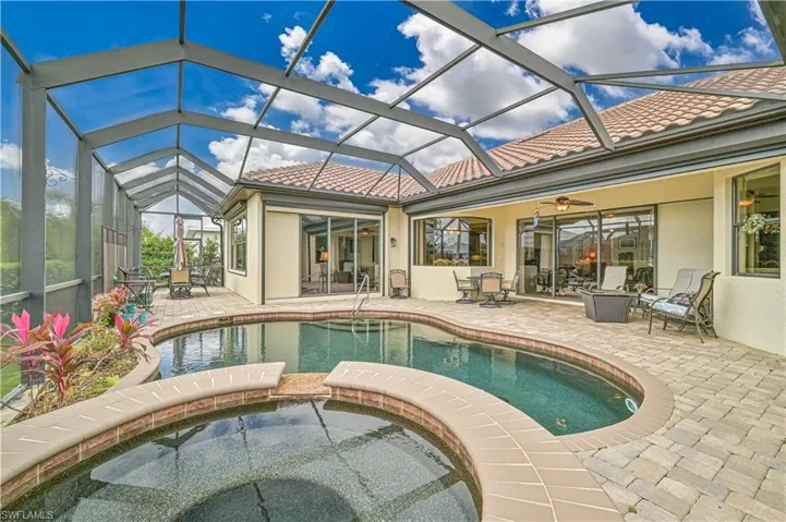 View of swimming pool featuring an in ground hot tub, a patio, glass enclosure, and ceiling fan