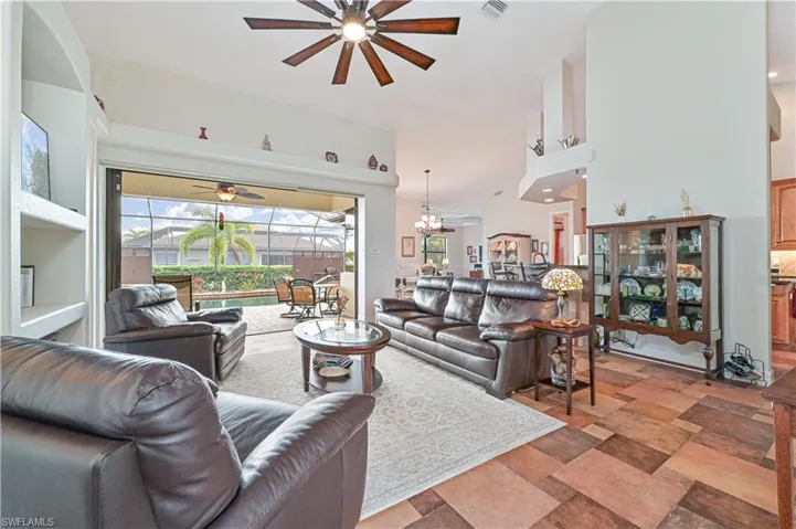 Living room with ceiling fan with notable chandelier
