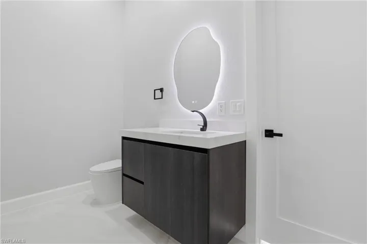 Floating vanity with a wood-finish facade, integrated sink, and white countertop