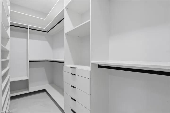 Custom closet system featuring white shelving and integrated drawers