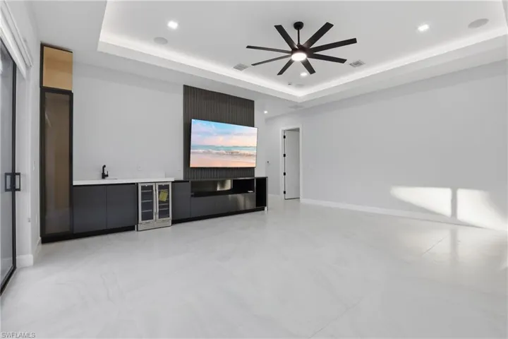 Spacious room featuring large format tile flooring, a contemporary ceiling fan, and recessed lighting