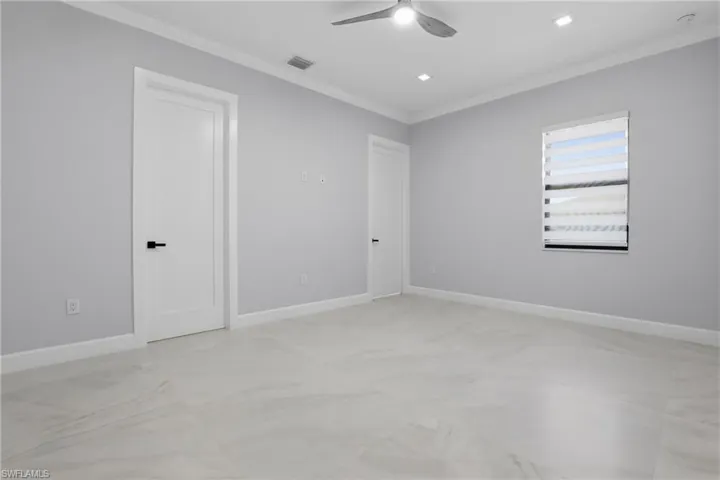 Spacious room with light-toned flooring, modern ceiling fan, recessed lighting, and crown molding