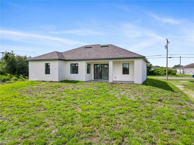 Rear view of house with a lawn