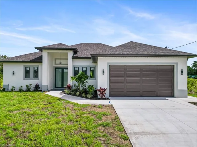 Prairie-style home with a garage and a front lawn