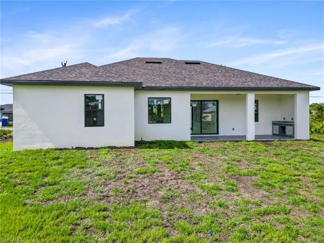 Back of house with a patio and a yard