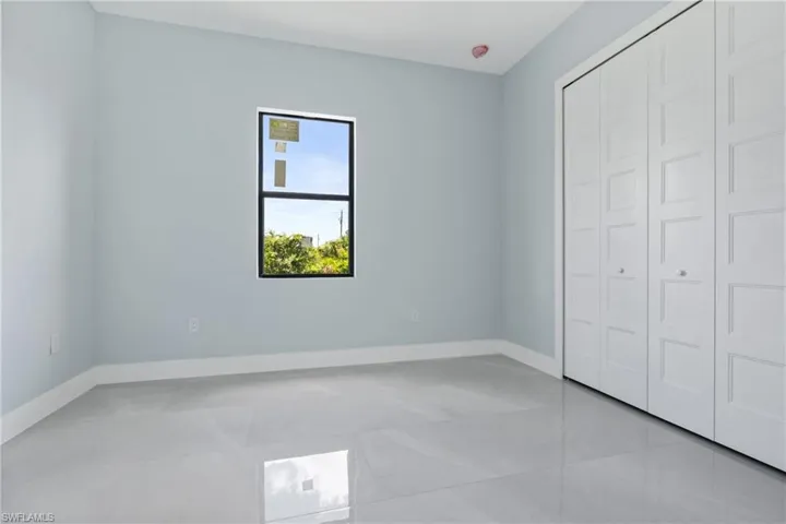 Unfurnished bedroom with a closet and light tile patterned floors