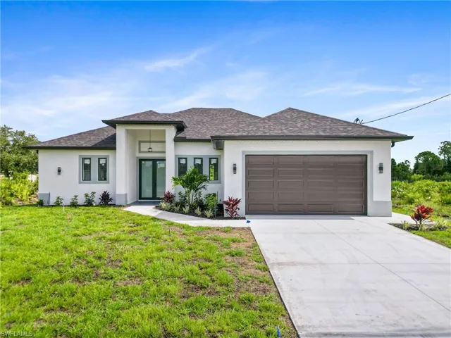 View of front of home featuring a garage and a front lawn