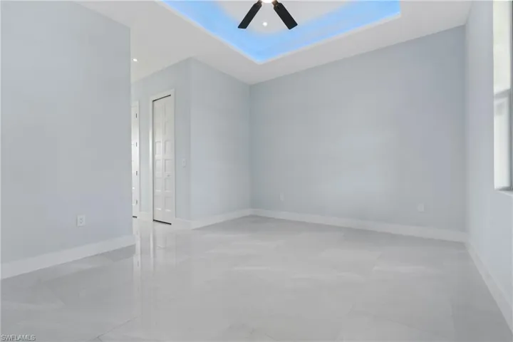 Tiled spare room featuring ceiling fan