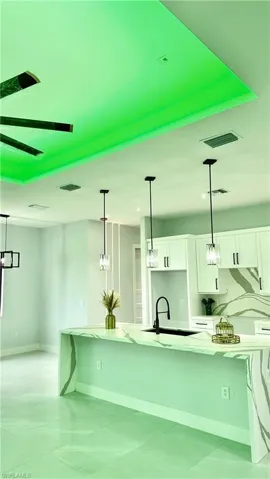 Kitchen with sink, decorative light fixtures, light tile patterned floors, and white cabinets