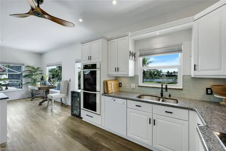 Kitchen features white shaker cabinets, high-end appliances, and water views.