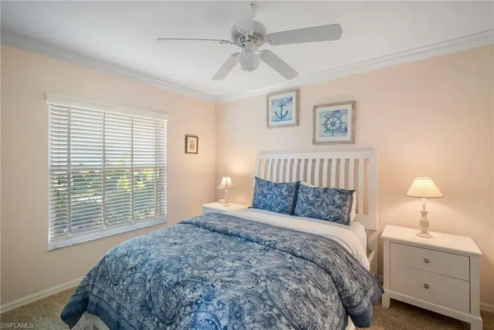 Bedroom with ornamental molding, carpet, and ceiling fan