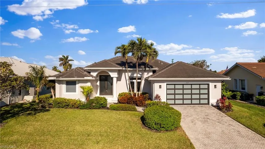 View of front of property featuring a garage and a front yard