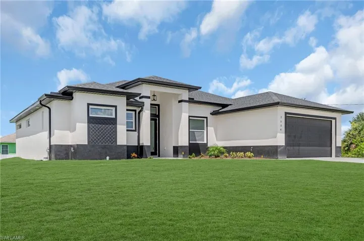 Prairie-style home with a garage and a front lawn