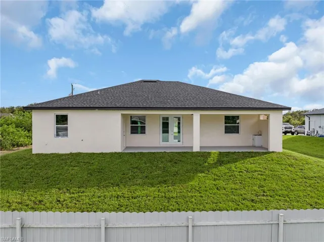 View of side of property with a lawn and a patio area