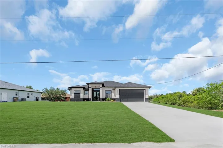 Prairie-style house with a garage and a front lawn