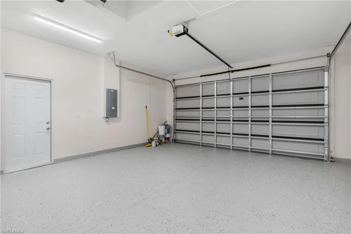 Garage featuring electric panel and a garage door opener