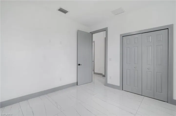 Unfurnished bedroom with a closet and light tile patterned floors
