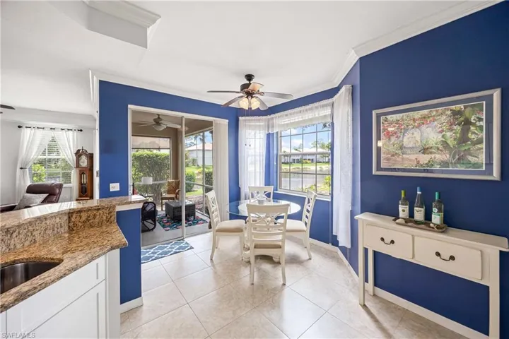 Dining area with ornamental molding, light tile patterned flooring, baseboards, and ceiling fan