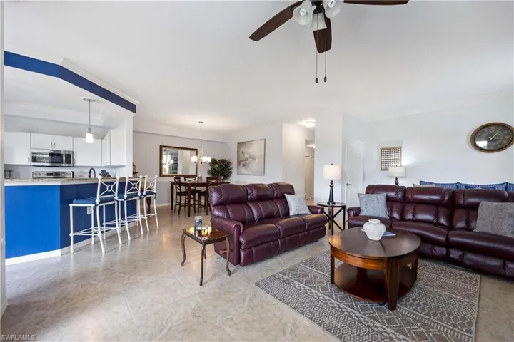 Living area with crown molding and a ceiling fan