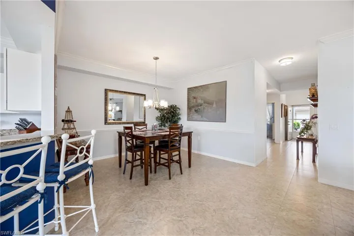 Dining room featuring crown molding, baseboards, and a chandelier