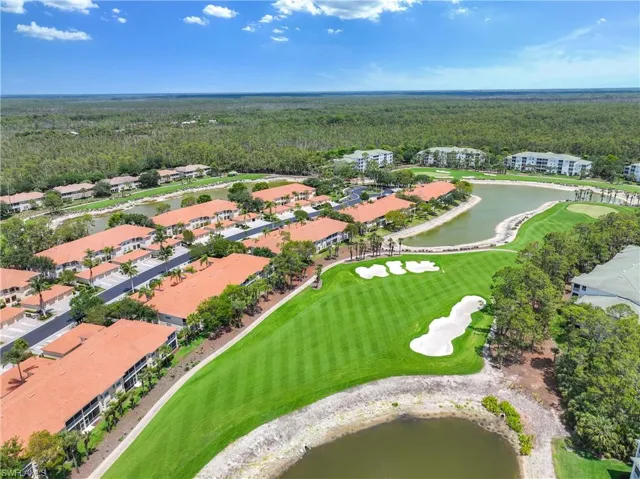 Drone / aerial view of a forest, a nearby body of water, and a local golf course