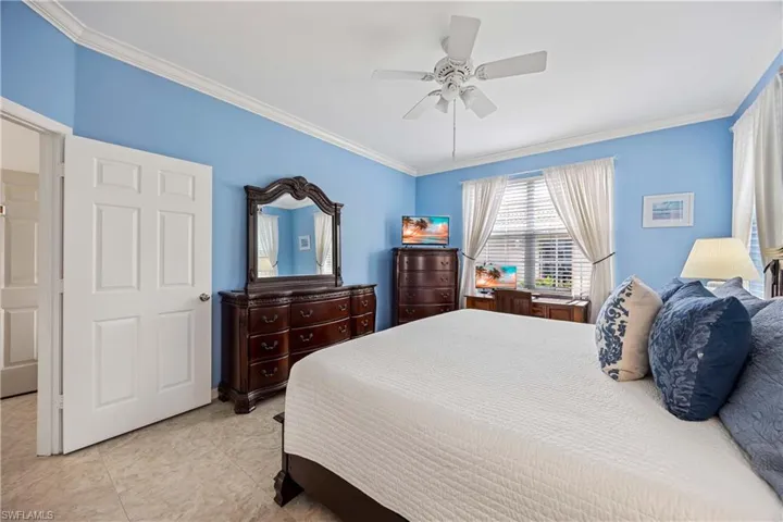 Master Bedroom with ornamental molding, ceiling fan, and light tile patterned flooring
