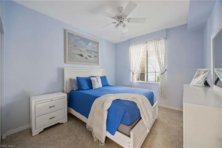 Guest Bedroom featuring baseboards, light tile patterned floors, and a ceiling fan