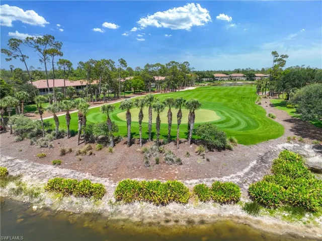 View of property's community with golf course view, a water view, and view of scattered trees