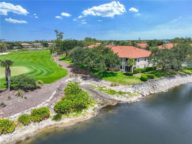 Aerial view of property and surrounding area featuring a large body of water and a golf club
