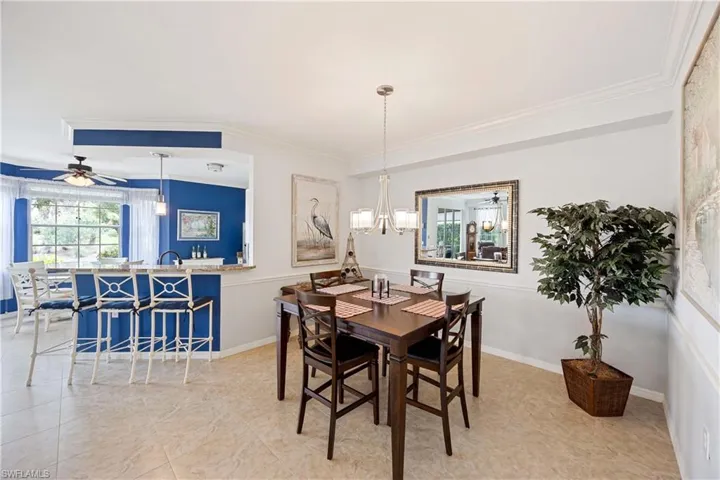 Dining room featuring a chandelier, ornamental molding, and ceiling fan