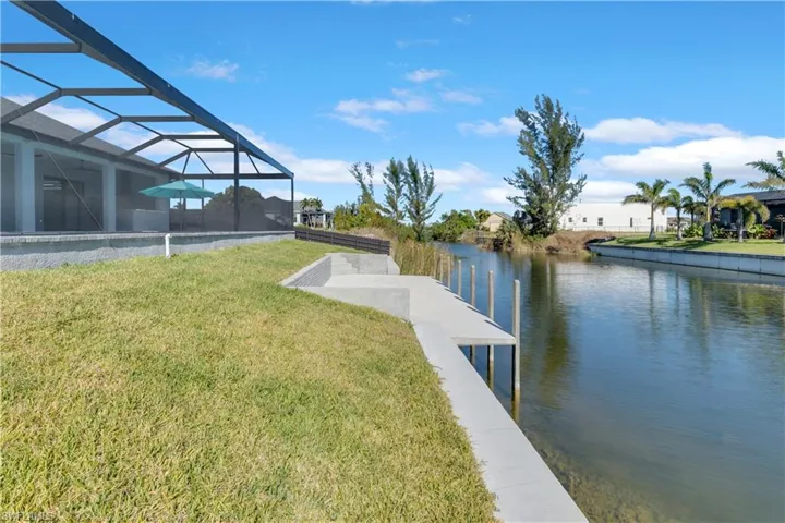 Dock area featuring a lanai, a yard, and a water view