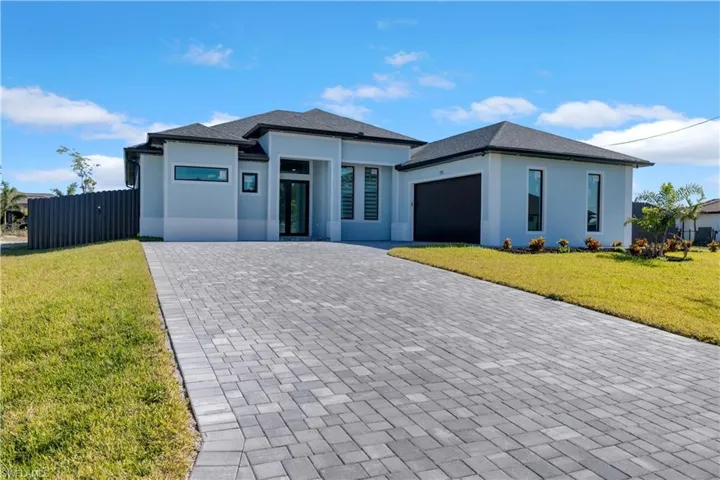 View of front of house with a front yard and a garage