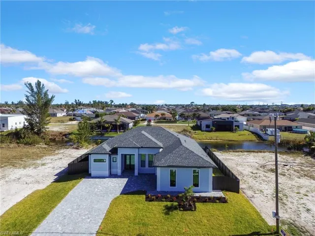 View of front facade with a water view, a front yard, and a garage