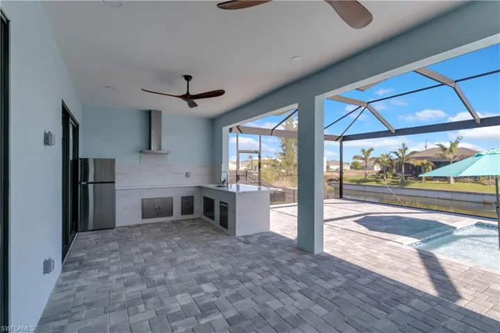 View of patio featuring ceiling fan, a lanai, and a wet bar