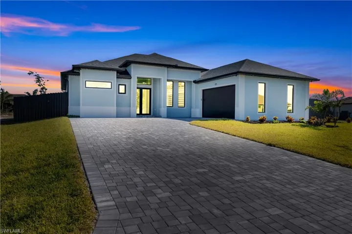 View of front facade with a lawn and a garage