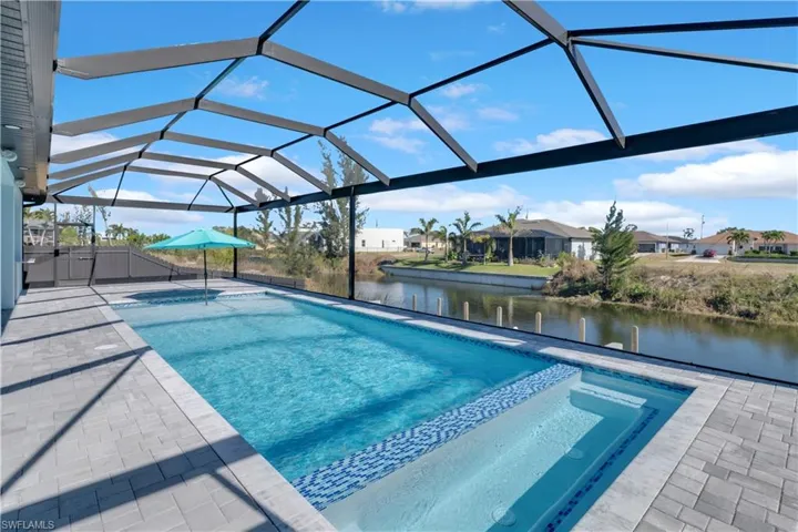View of pool with a lanai, a water view, and a patio