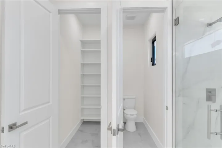 Bathroom with toilet and a shower with shower door