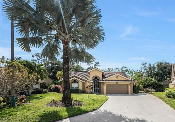 Mediterranean / spanish-style home featuring a garage and a front lawn