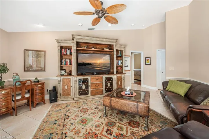Tiled living room with vaulted ceiling and ceiling fan