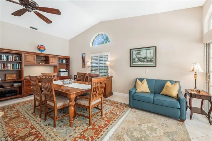 Dining space featuring high vaulted ceiling, plenty of natural light, light tile patterned floors, and ceiling fan