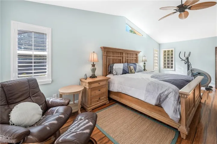 Bedroom featuring multiple windows, hardwood / wood-style flooring, and lofted ceiling