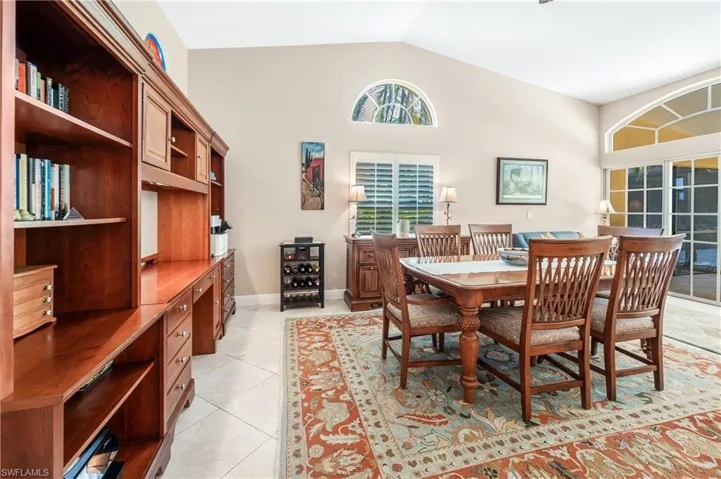 Tiled dining area featuring high vaulted ceiling