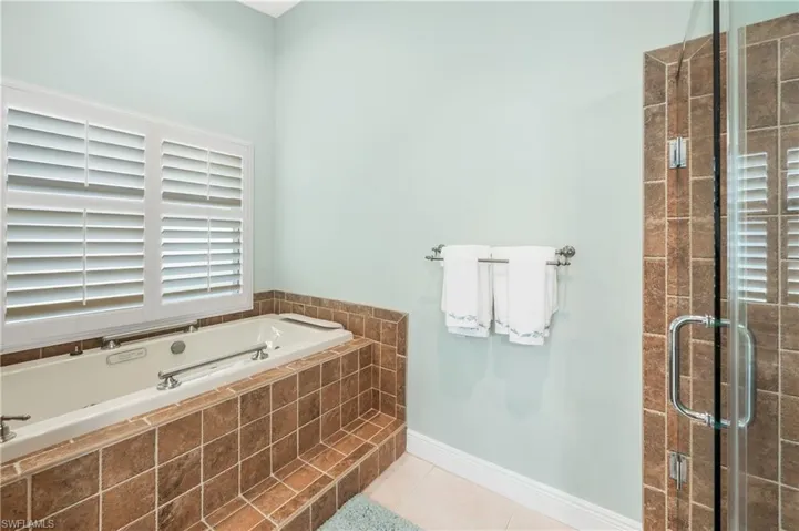 Bathroom featuring plus walk in shower and tile patterned floors