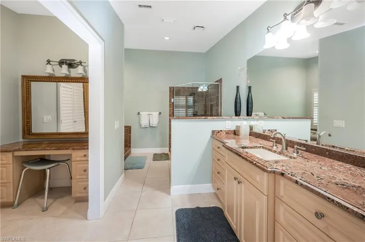 Bathroom featuring vanity, tile patterned flooring, and walk in shower