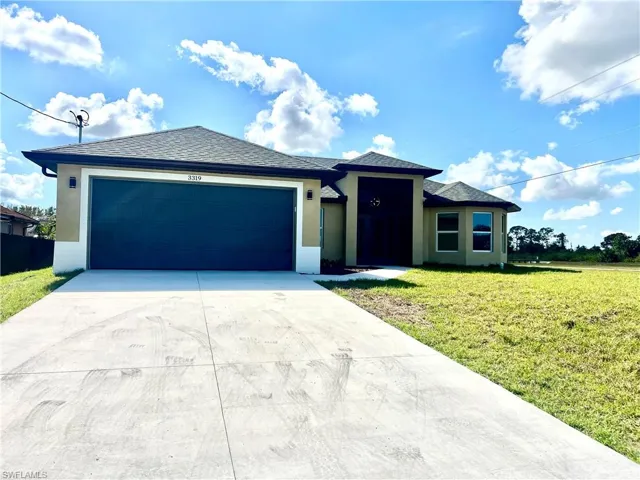 View of front of home with a garage and a long driveway with plenty of parking.