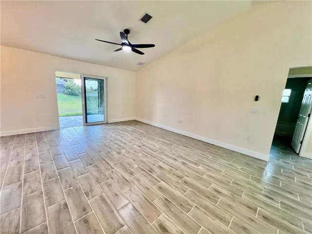 Cathedral ceilings in living room with wood plank porcelain tile floors.