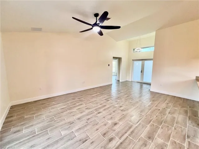 Cathedral ceilings in living room with wood plank porcelain tile floors.