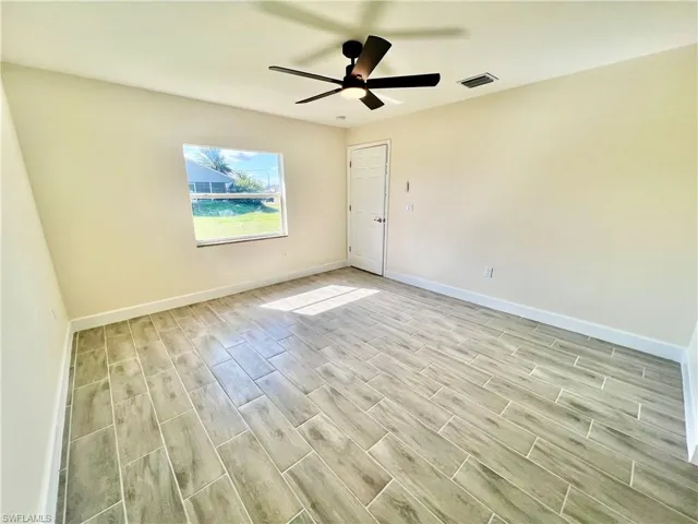 Primary bedroom with wood plank porcelain tilel floors.