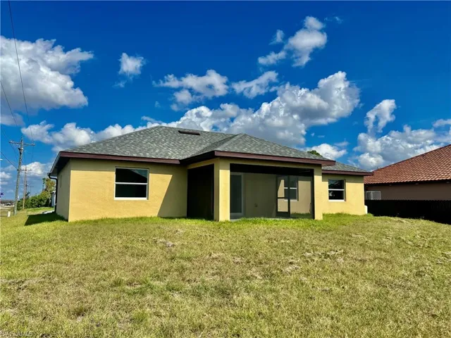 Rear view of property with a yard