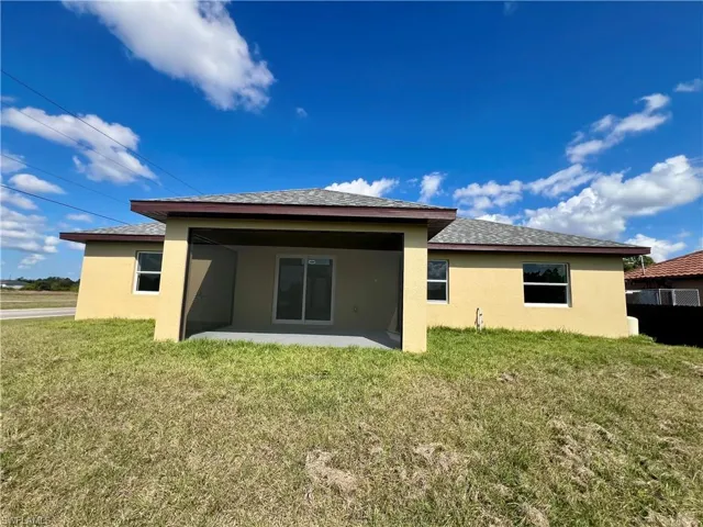 Back of house with a yard and a screened lanai.